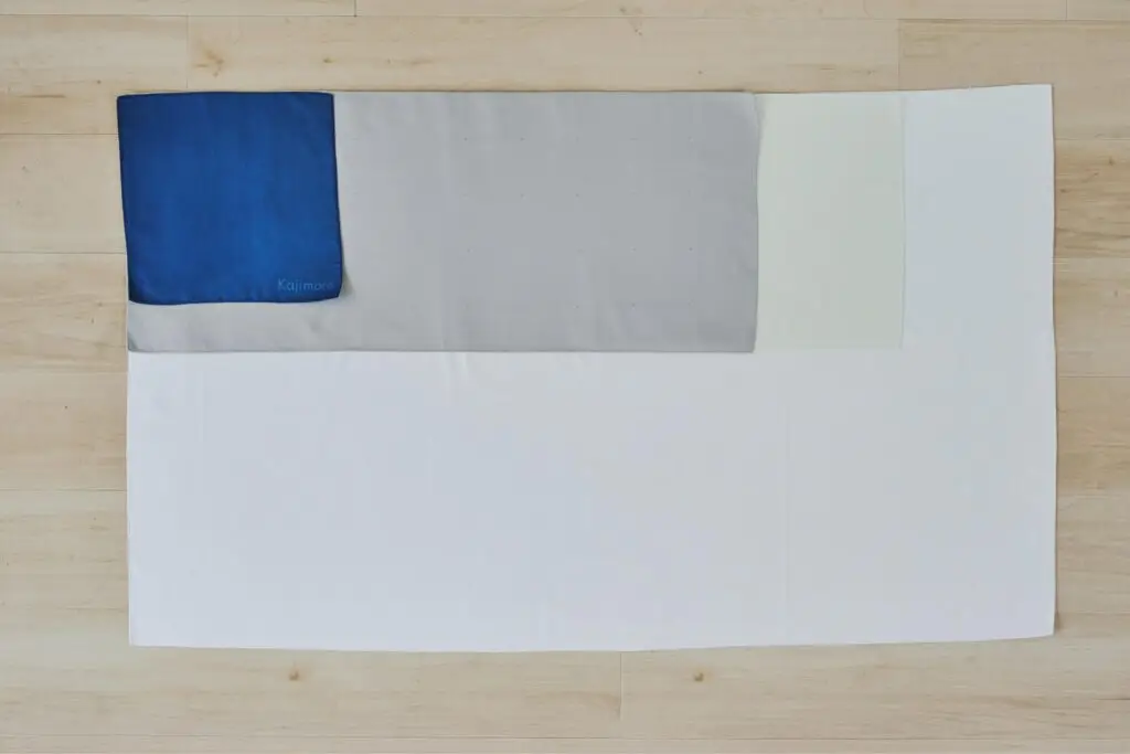 Kajimoreのホワイトのタオルの上に、他の4色のタオルが並べられ、サイズの違いを比較している画像。