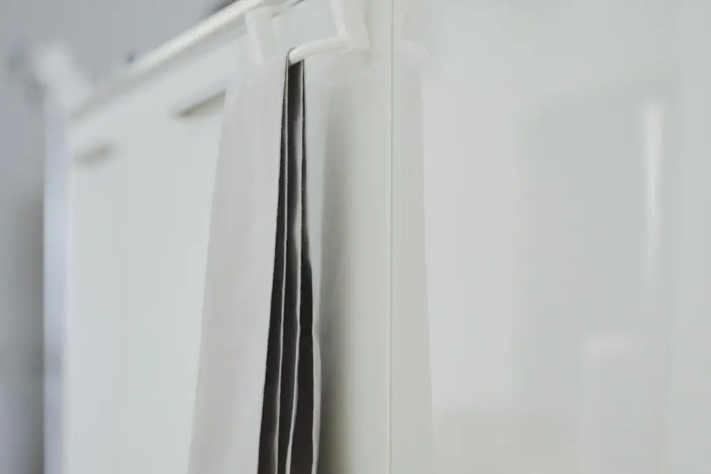 Kajimoreのグレーのタオルが、バスルームのタオル掛けに干されている画像。タオルの薄さがよく分かります。