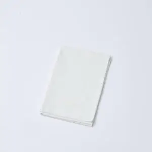 Kajimoreのアイボリーのハンドタオルが、コンパクトに折りたたまれており、ロゴが写っている画像。