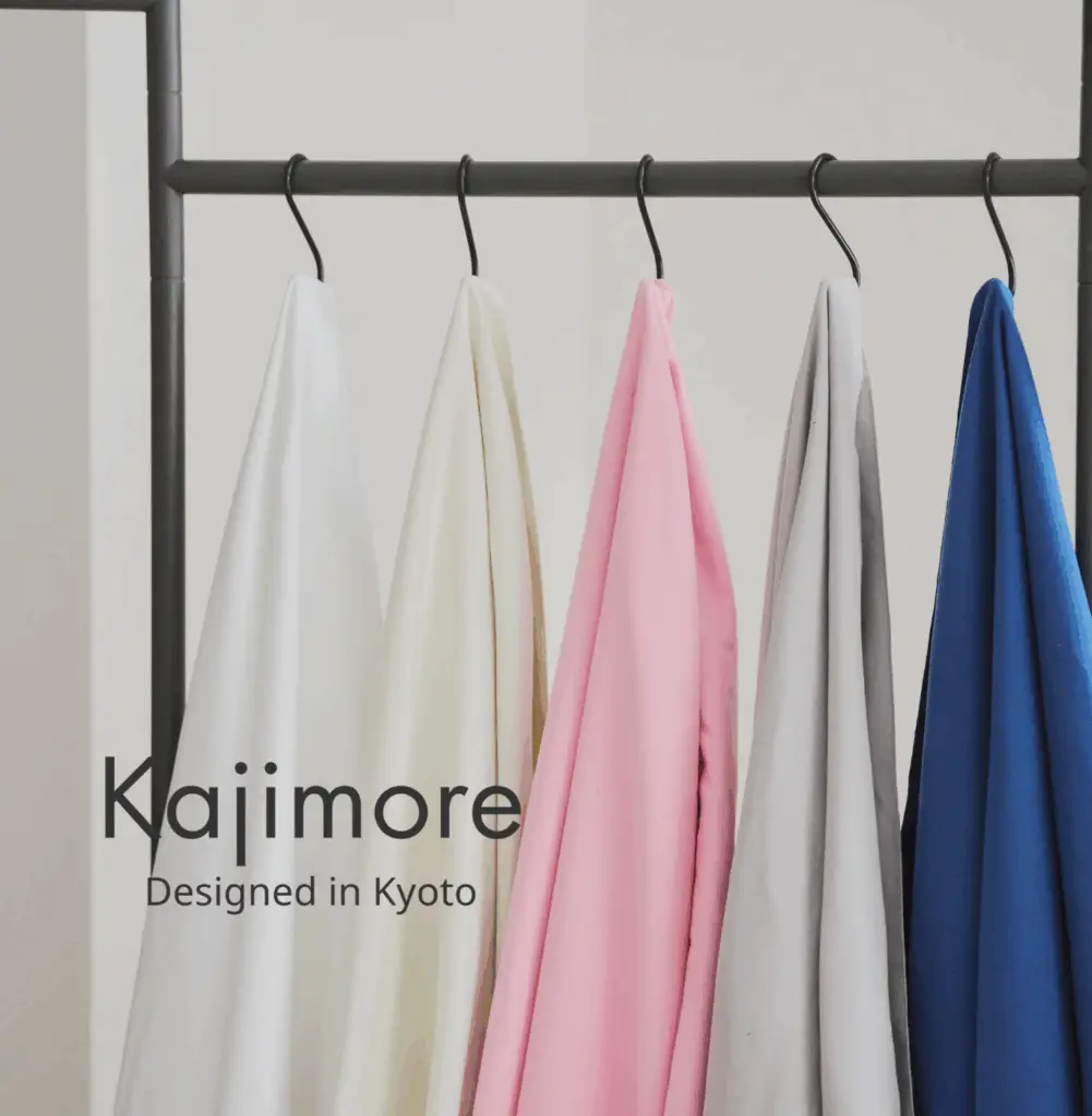 Kajimoreの5色（ホワイト、アイボリー、ピンク、グレー、ブルー）がハンガーに美しく並べられた画像。Designed in Kyotoのロゴ入り。