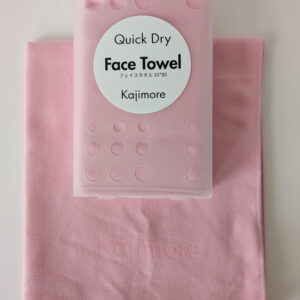 ピンクの速乾フェイスタオルと、その上に重ねられた専用ハードケース。タオルの端に「Kajimore」のロゴ刻印が確認できる。