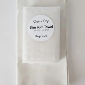 アイボリーのスリムバスタオルとハードケース。 清潔感のある優しい色味が、半透明のケース越しにも確認できる。